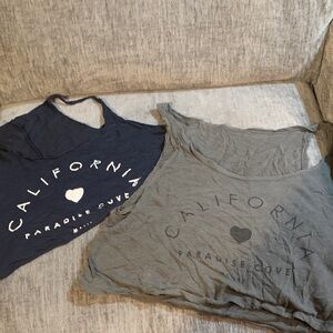 Two California Paradise Cove Graphic Sleeveless Tees. One navy and one gray.
